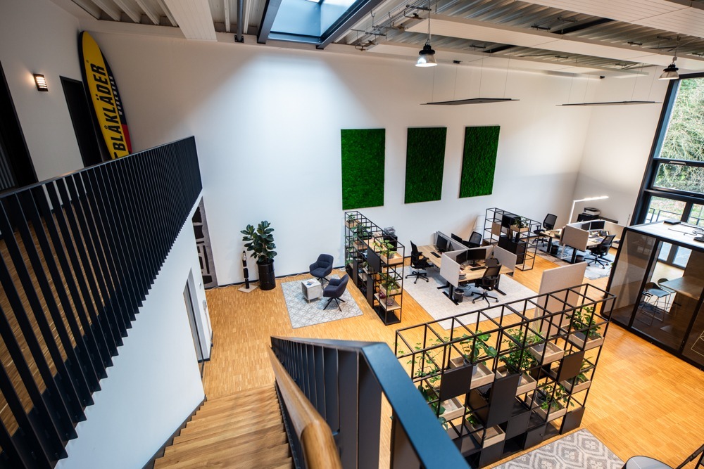 Grote open werkplekken met duo bureaus. 